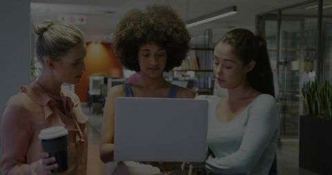 Trio of Professional Women Analyzing Data on Laptop in Open-Plan Office