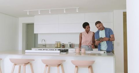 Diverse Couple Reviewing Blueprints and Discussing Ideas