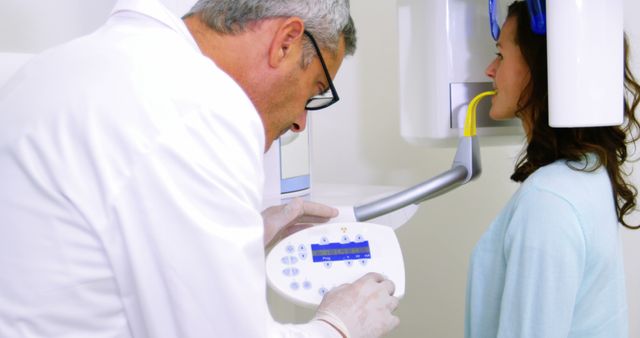 Dentist Operating X-ray Machine with Patient Standing Nearby - Download Free Stock Images Pikwizard.com