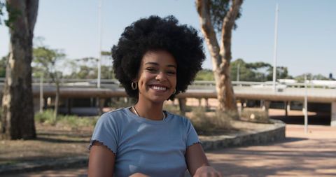 Smiling Biracial Woman with Natural Hair in Sunny Park