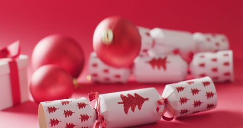 Festive christmas crackers with red ornaments on vibrant background