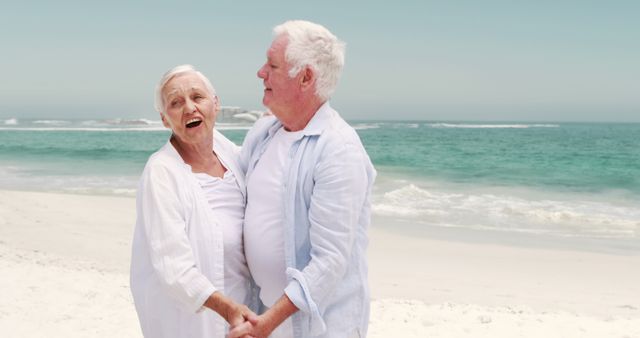 Old retired couple dancing together on the beach