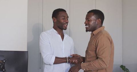 Close Friends Smiling and Hand-Shaking in Living Room Setting