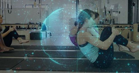 Women practicing Pilates holding medicine balls on mats with holographic globe overlay for fitness