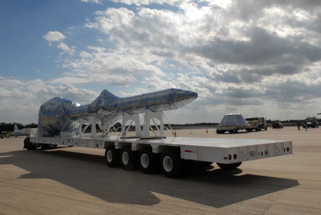 Ares I-X rocket hardware being offloaded from aircraft at NASA Kennedy Space Center. Part of preparations for unpiloted rocket launch aimed at enhancing space exploration. Useful for educational materials, aerospace studies, articles on space missions and engineering projects.