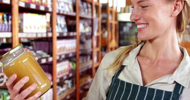 Smiling Woman Holding Glass Jar in Grocery Store - Download Free Stock Images Pikwizard.com