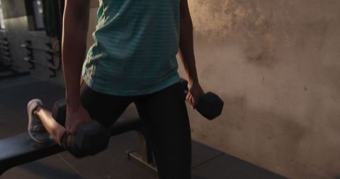 Athletic Woman Performing Dumbbell Lunges in Gym