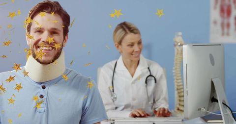 Smiling male patient wearing cervical collar consulting female doctor typing clinic computer