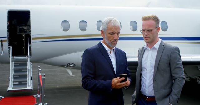 Businessmen Discussing While Standing Near Private Jet - Download Free Stock Images Pikwizard.com