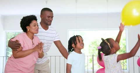 Joyful African American Family Bonding at Home with Balloon Play