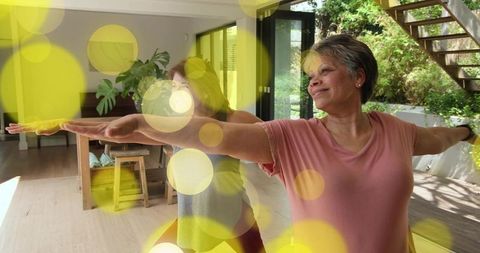 Senior woman practicing yoga with partner at home boosting balance, flexibility, active aging