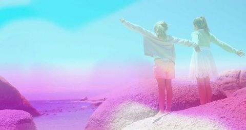 Carefree Girls Embracing Adventure by Ocean Rocks with Pastel Sky