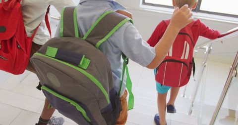 Children Descending Stairs with Backpacks at School