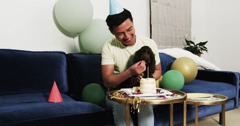 Man Celebrates Party with Puppy on Sofa
