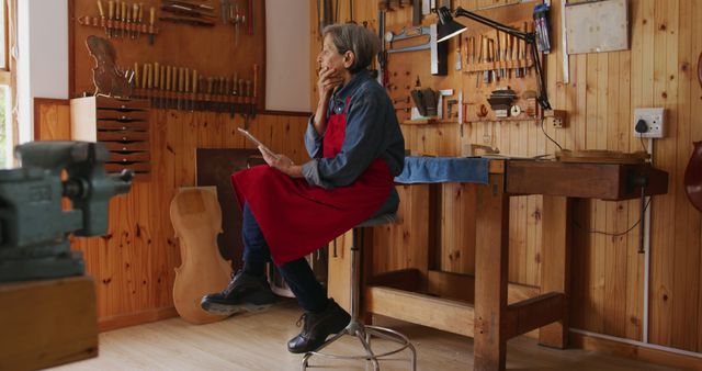 Craftsperson Thinking in Wood Workshop Wearing Red Apron - Download Free Stock Images Pikwizard.com