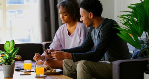 Couple Enjoying Intimate Breakfast Together on Sofa