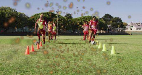 Youth soccer players dribbling through cone drill on sunny grass field boosting teamwork