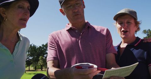 Senior friends reviewing golf scores together
