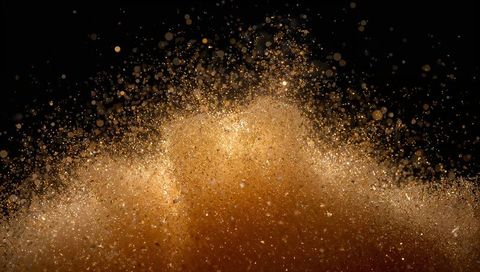 Rising golden-brown powder cloud with glittering particles and warm bokeh motion