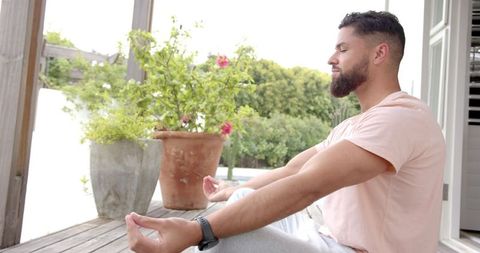 Man Meditating on Sunny Deck for Wellness and Relaxation