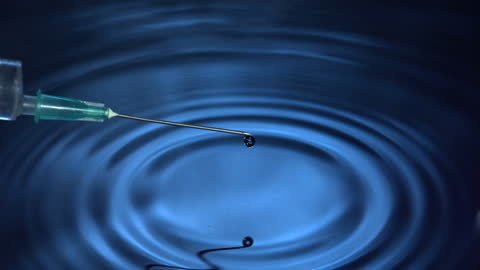 Slow Motion Needle Dropping Water Ripple in Blue