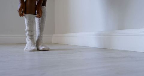 Person Adjusting Cozy Knit Socks Indoors