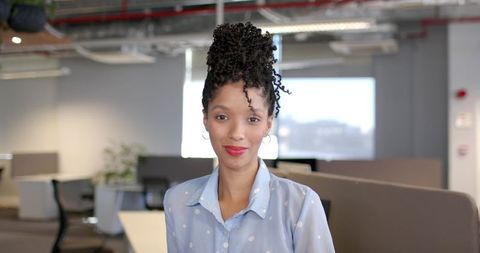 Confident african american woman standing in modern open office with daylight