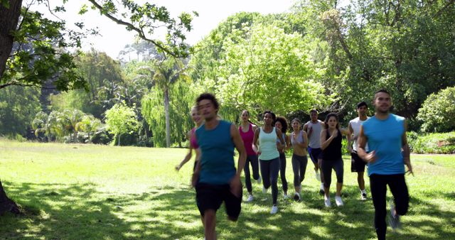 Group of friends jogging outdoors in a sunny park surrounded by greenery. Ideal to depict healthy living, fitness activities, teamwork, and the joy of exercising together in nature. Useful for ads related to fitness, wellness programs, outdoor activities, and community events promoting healthy lifestyles.