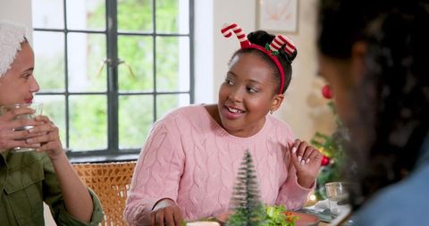 Joyful Christmas Gathering of Friends Sharing Meal at Festive Table