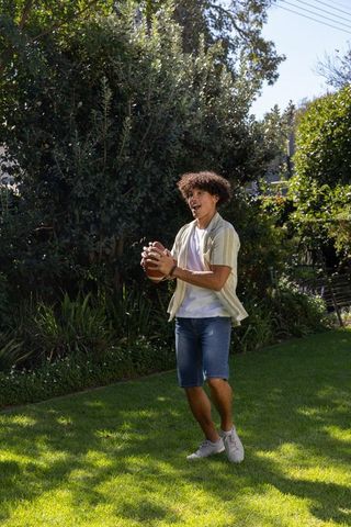 Energetic African American Man Preparing to Throw Football Outdoors