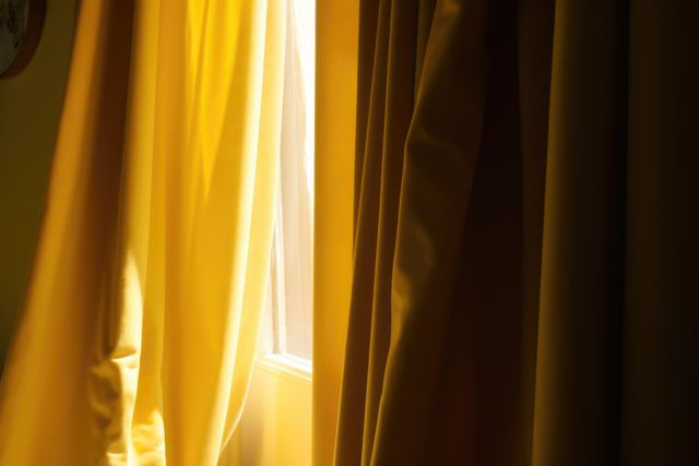 Yellow curtains hanging in room with window, created using generative ai technology. Interior design, home decor and fabric concept digitally generated image.