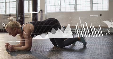 Female athlete holding forearm plank with fitness data overlay in modern gym