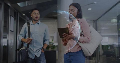 Colleagues Utilizing Tablet Technology in Modern Office Corridor