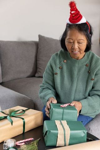 Senior Woman Enjoying Festive Gift Wrapping in Cozy Setting