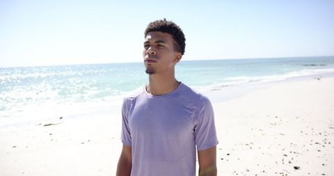 Young Man Relaxing on Sunny Beach with Peaceful Expression - Download Free Stock Images Pikwizard.com