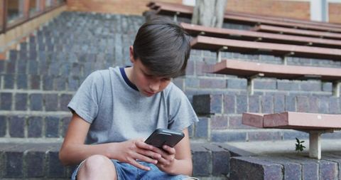 Focused Boy Engaging with Smartphone Technology Outdoors - Download Free Stock Images Pikwizard.com