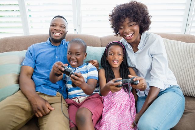 Family enjoying quality time playing video games in living room. Perfect for themes related to family bonding, leisure activities, home entertainment, and technology use in everyday life.
