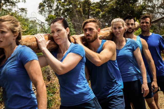 Fit people carrying a heavy wooden log during boot camp training