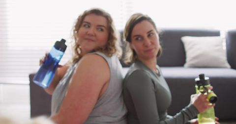 Two Women Enjoying Refreshing Break During Workout