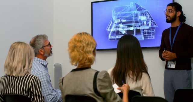 An architect is presenting a building design to a team. They are indoors with a monitor displaying an interactive blueprint. This scene is particularly useful for illustrating concepts of team collaboration, professional environments, architectural planning, and project management presentations.