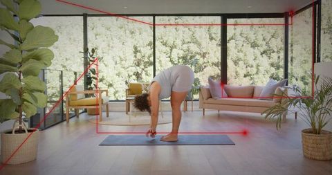 Woman practicing forward fold yoga in modern minimalist living room with red laser overlay
