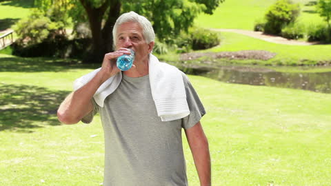 Active Senior Hydrating in Peaceful Park Setting
