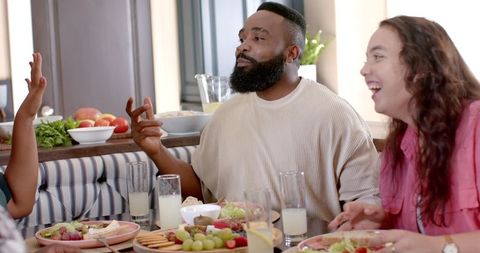 Diverse Friends Enjoying Meal together at Dining Table