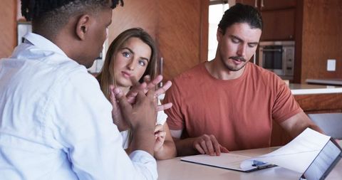Young Adults Collaborating Around Table with Documents