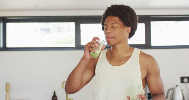 Fit african american man cooking, drinking healthy green smoothie - Download Free Stock Photos Pikwizard.com
