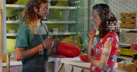 Vendor presenting red cheese wheel at cheese shop counter
