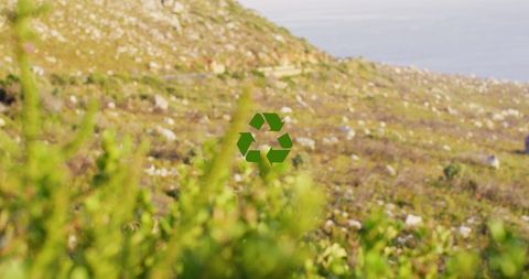 Green recycle symbol over serene landscape for sustainability concept