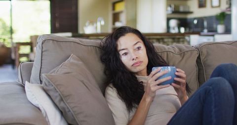 Reflective Woman Drinking Coffee Relaxed at Home
