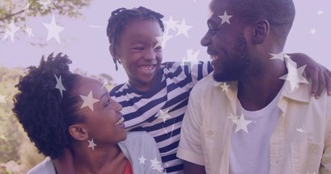 Smiling Family Sharing a Warm Embrace Outdoors Under a Starry Overlay