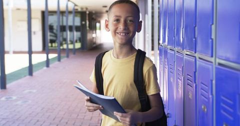 Biracial Boy Standing by Lockers with Folder in Hand, Ready for School
